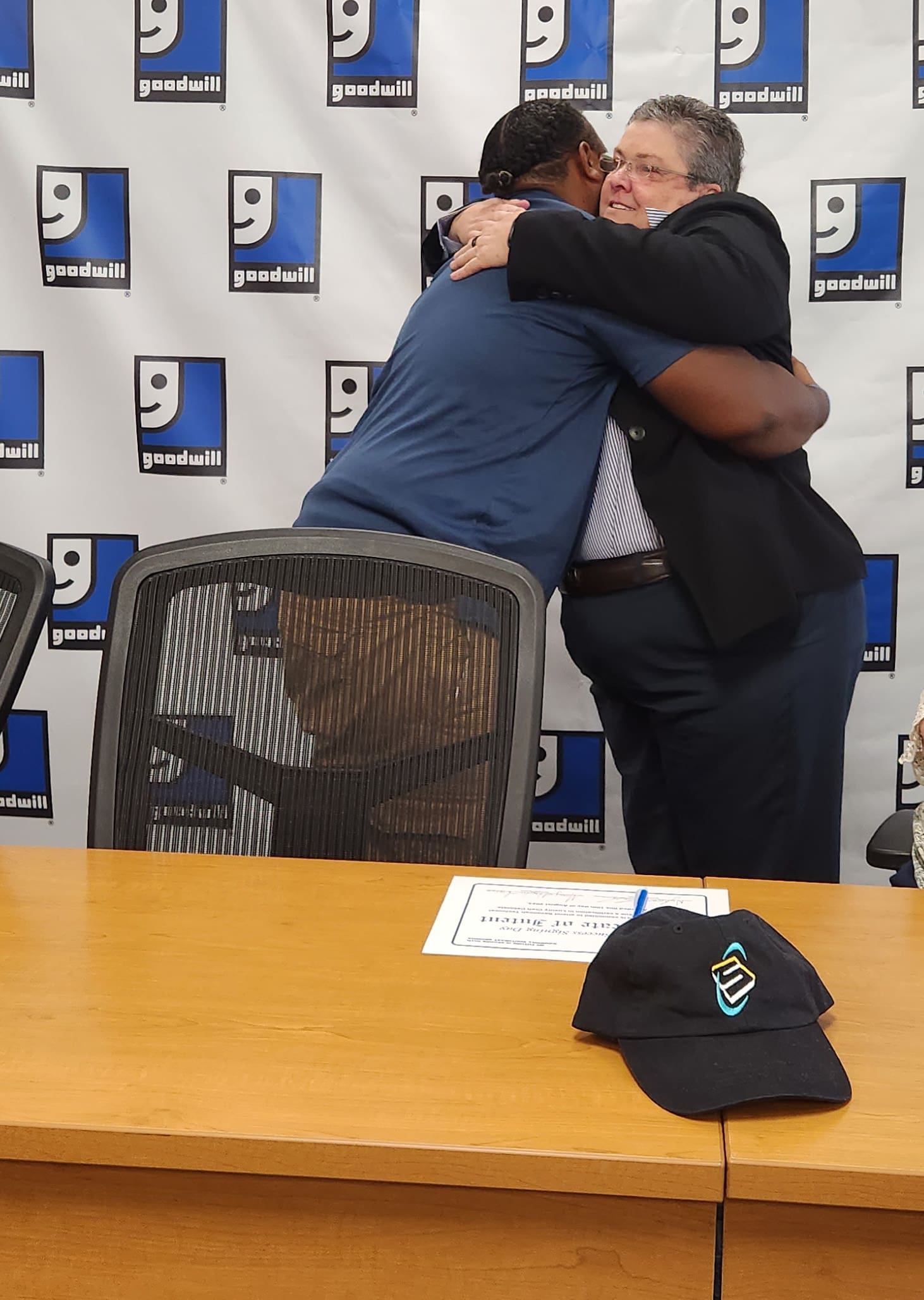 Peggy Burgoon, Manager of Associate Success, hugs Nyheem Houston, a Goodwill Associate, after he announces his academic commitment to Savannah Tech. 