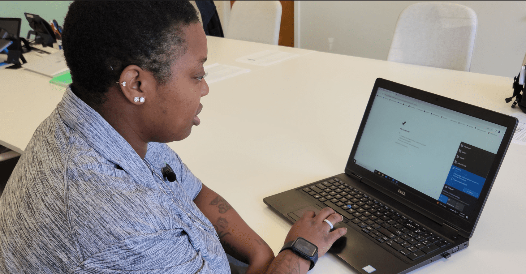 Tahitia works to restore the Wi-Fi connection on a laptop inside Goodwill Southeast Georgia's ReFactory office.