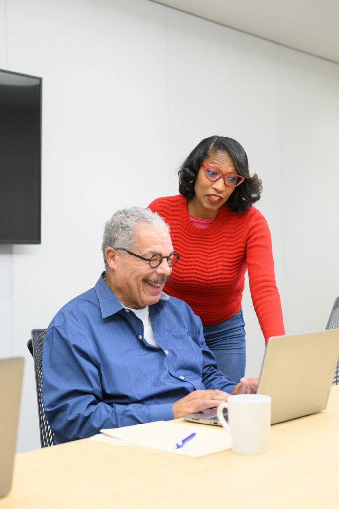 Woman helping man at a computer